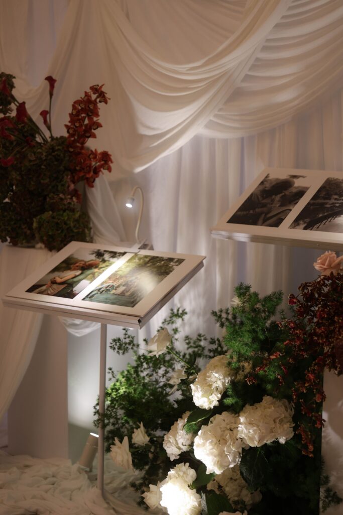 Modern classic wedding photograph display with layered drapery backdrop, floral accents, and intimate personalised styling details at Raffles Hotel Singapore