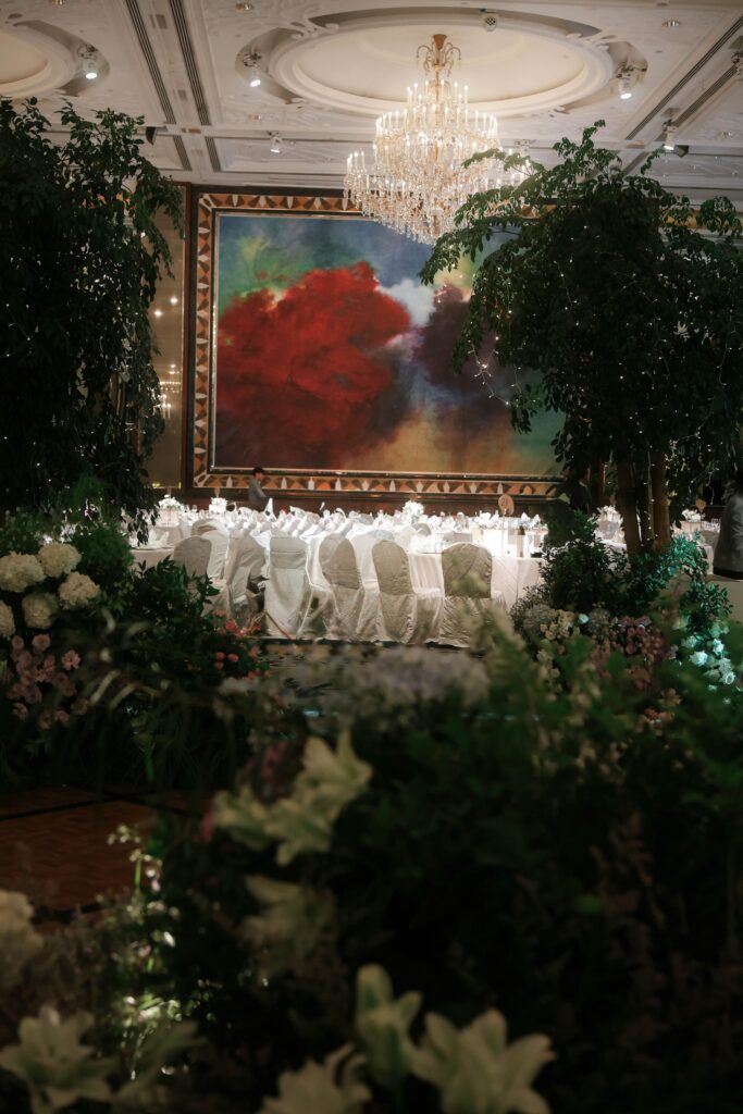 Large statement wedding trees with layered white floral arrangements creating immersive ballroom aisle styling at Shangri-La Singapore