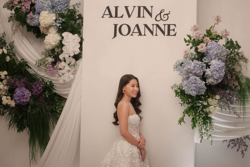 Soft draped wedding photo backdrop styled with pastel hydrangeas, white florals, and organic greenery at Shangri-La Singapore