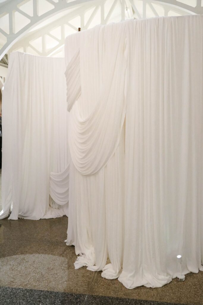 Flowing white drapery styling used to soften a structured wedding installation and enhance spatial balance, The Clifford Pier Singapore