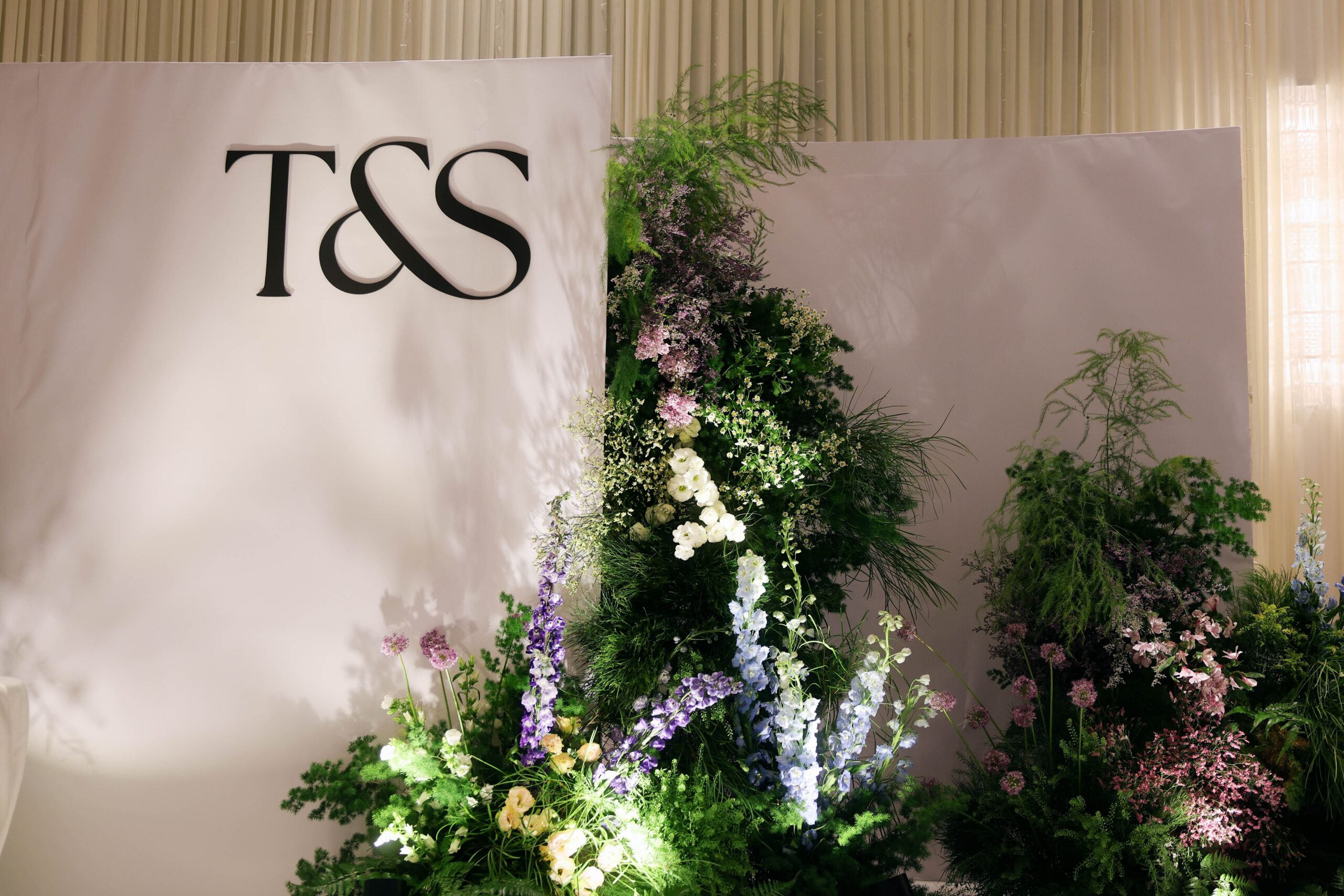 Alpine-inspired floral stage featuring layered wildflower arrangements, lush greenery, natural textures, and organic floral styling for a nature-inspired ballroom wedding at Westin Singapore.