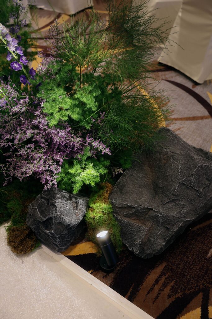 Natural rock and floral arrangement featuring lush foliage, layered greenery, wildflower-inspired blooms, and moss designed in an organic alpine style at Westin Singapore.