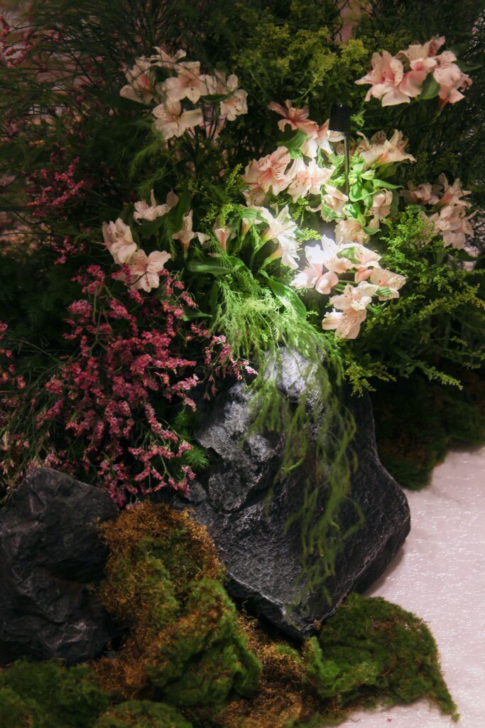 Organic aisle floral cluster featuring wildflowers, moss, natural rocks, soft pink blooms, and asymmetrical styling inspired by untouched mountain landscapes at Westin Singapore.