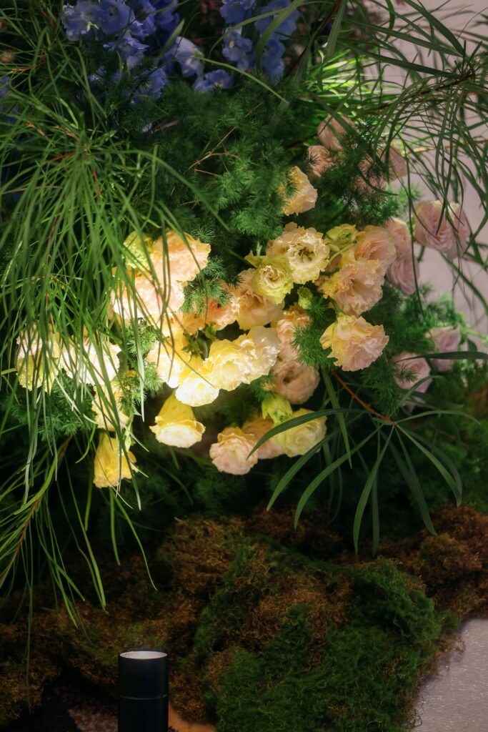 Organic floral cluster with soft yellow flowers, ornamental grasses, moss, and natural greenery arranged in a wildflower-inspired style for a ballroom wedding at Westin Singapore.