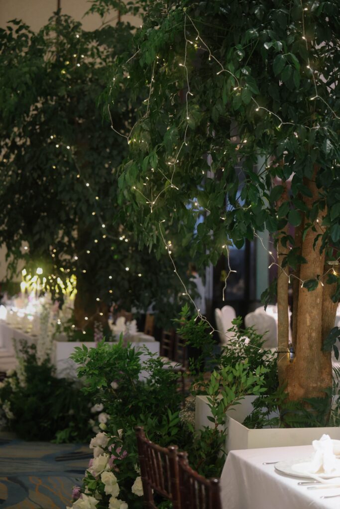 Organic indoor garden wedding styling with lush trees, layered greenery, and soft floral details inside the ballroom at Shangri-La Singapore