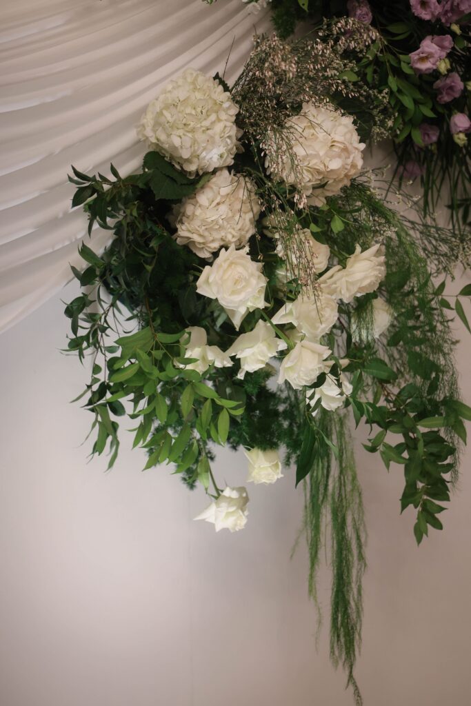 Cascading white floral arrangement with hanging orchids, lush greenery, and refined organic styling detail at Shangri-La Singapore