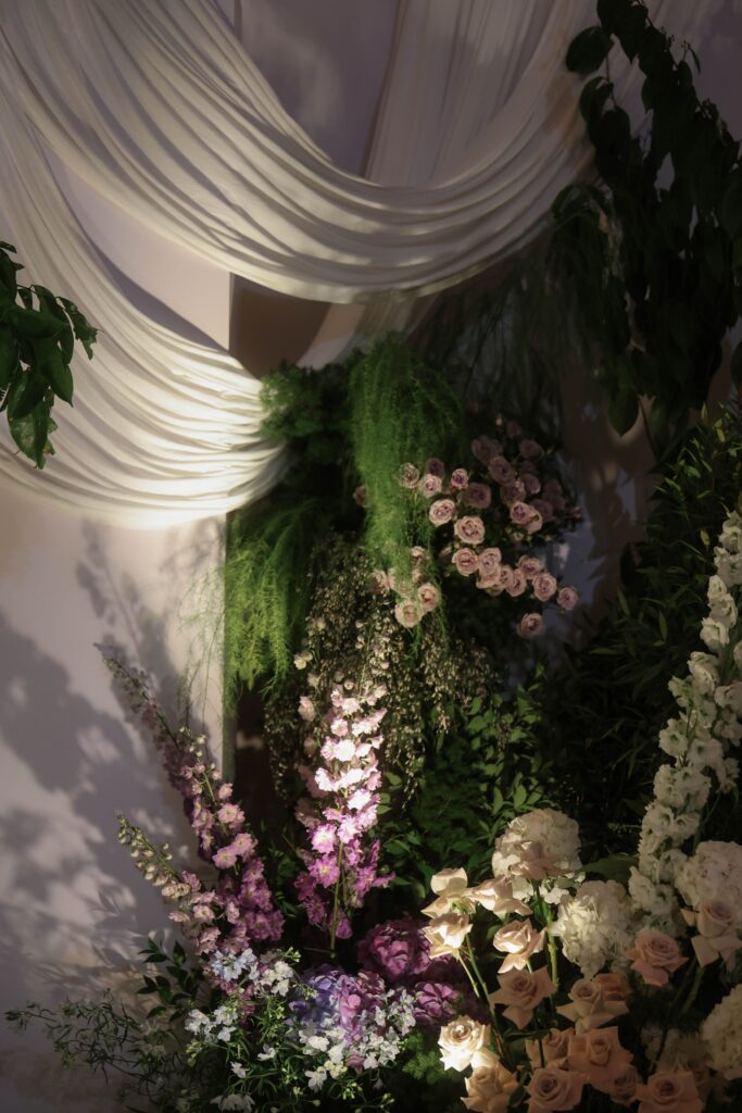 Soft draped wedding backdrop with pastel blue hydrangeas, white florals, and organic greenery styling in romantic ballroom design at Shangri-La Singapore