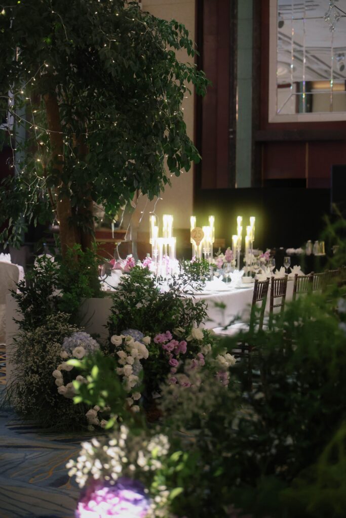 Tall wedding tree installation with soft blue and purple flowers, layered candlelight, and refined ballroom styling at Shangri-La Singapore