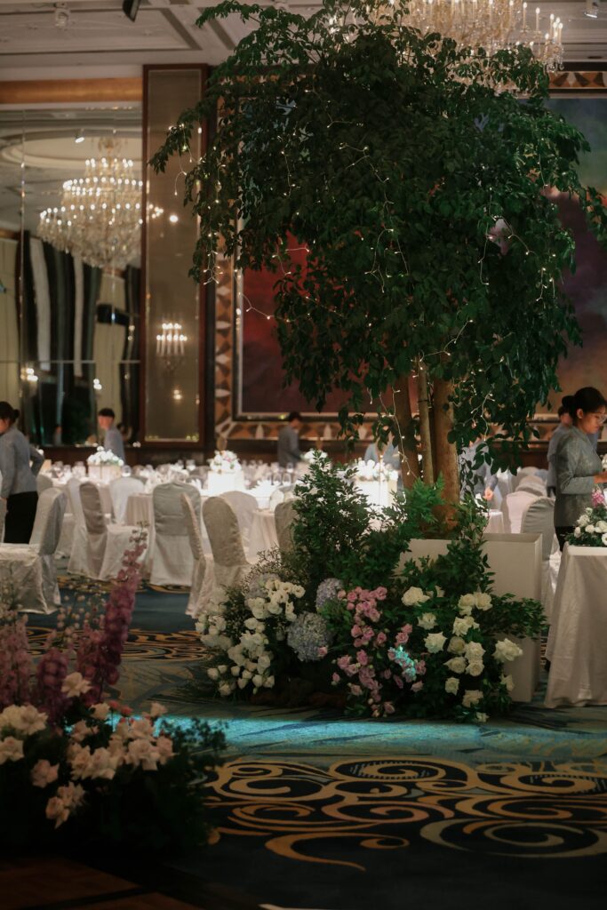 Towering wedding tree styling with soft floral clusters creating an immersive ballroom forest design at Shangri-La Singapore
