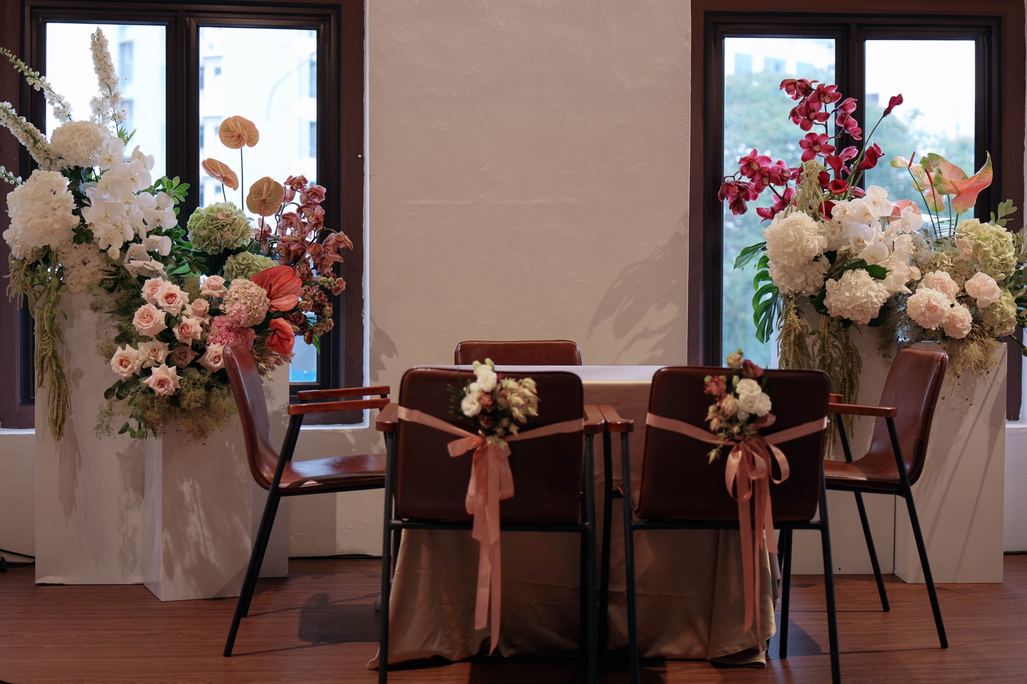 reception florals framing a sweetheart table with pink and white arrangements