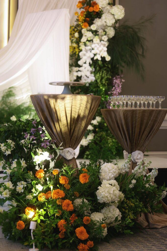 Gold urn at a St Regis marigold wedding with marigold and white hydrangea massed at the base