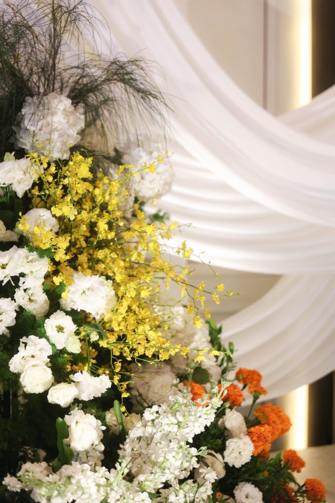 St Regis marigold wedding floral column of yellow oncidium, marigold and white blooms