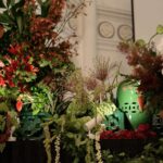 Chijmes wedding: green Peranakan jars with white orchids, red lilies and tropical foliage