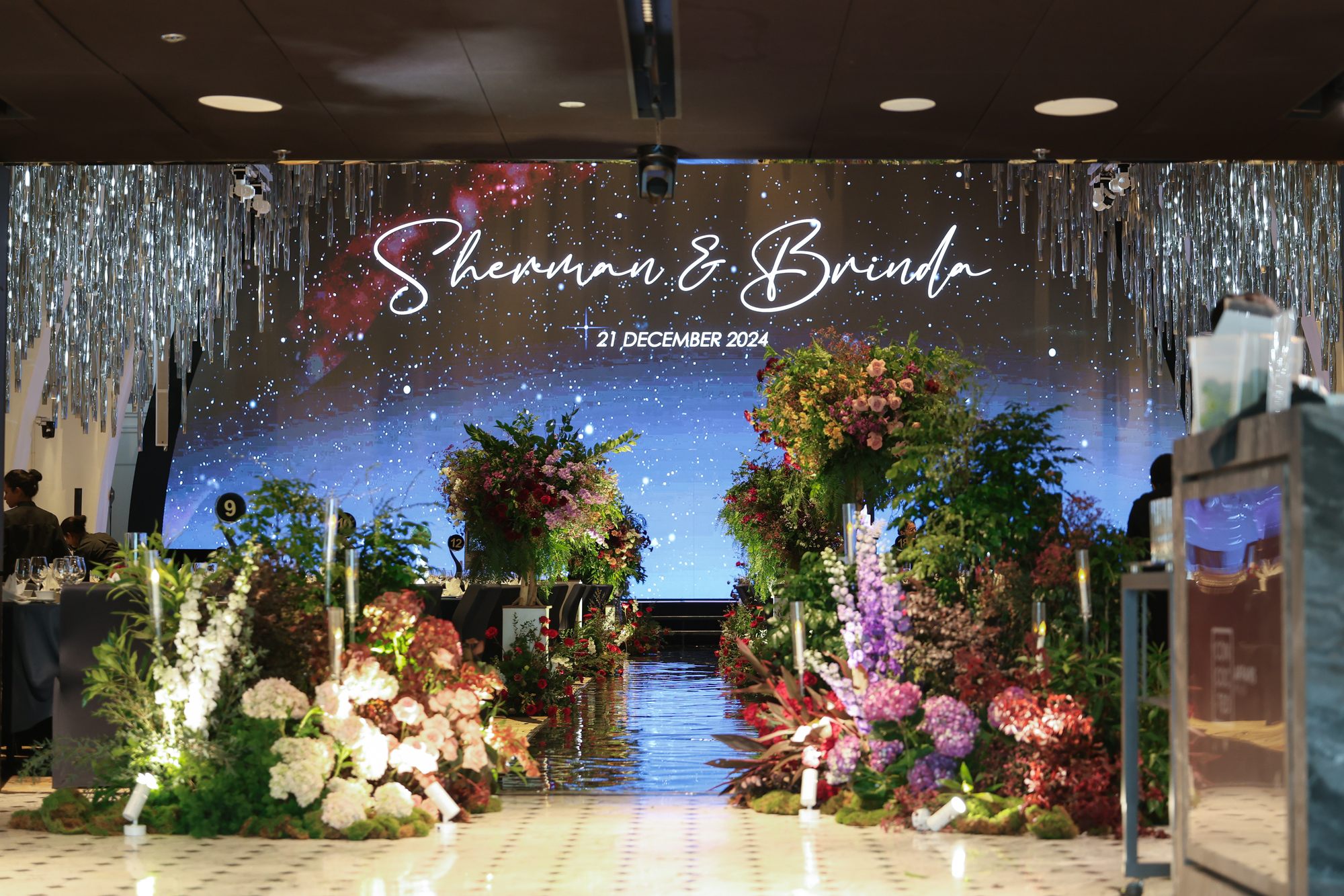 Starry night backdrop with the couple's name and maroon florals at a JW Marriott wedding