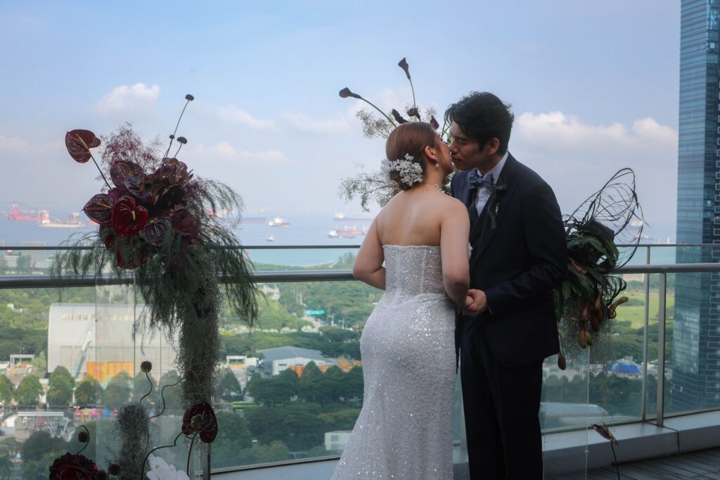 Couple with a deep burgundy bouquet on the VUE rooftop at a dark and moody wedding