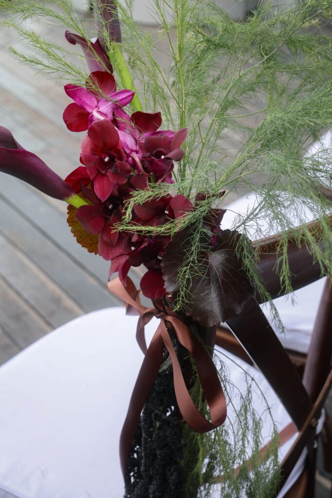 Black calla lily and magenta orchid tied to a chair at a VUE wedding, Singapore