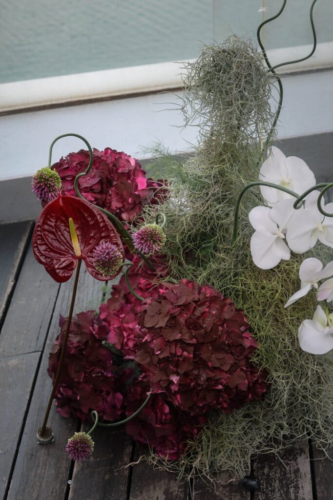 Dark anthurium, orchid and hydrangea installation at a moody VUE rooftop wedding