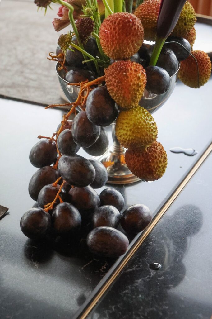 Fruit tower of mangosteen, lychee and grapes at a dark and moody VUE wedding