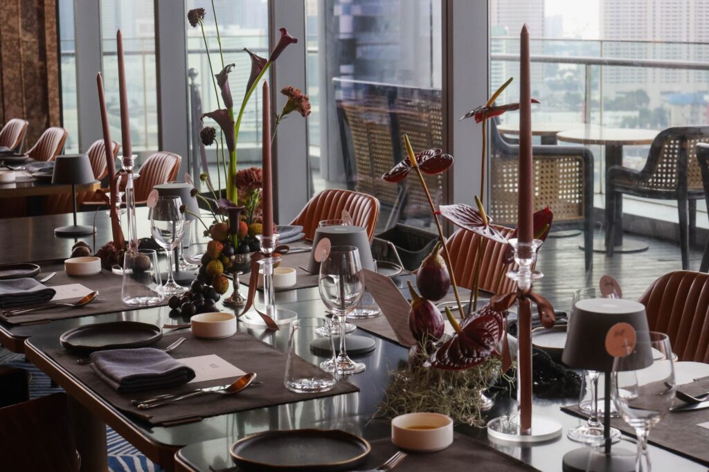Long moody banquet table with dark florals and fruit at a VUE wedding