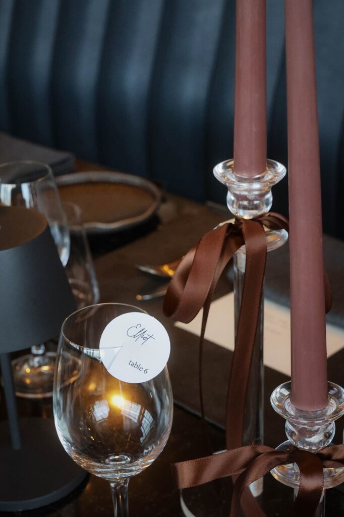 Wine glass name tag in candlelight at a moody VUE wedding, Singapore
