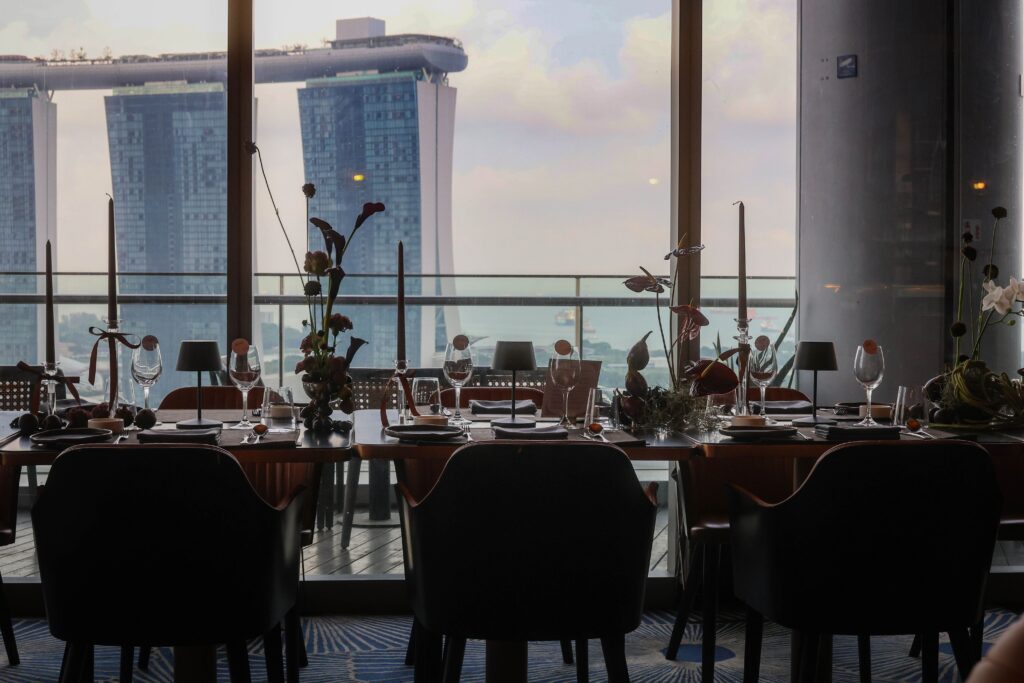Reception dining space with panoramic Marina Bay views and elegant floral styling for an intimate wedding at VUE Singapore.